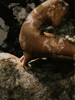 Photographie artistique d’un corps féminin nu dont la lumière de l'eau se reflète, dans une composition délicate et poétique.