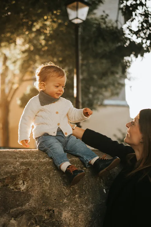 Portrait naturel d'un instant de complicité dans la rue entre une maman et son bébé.